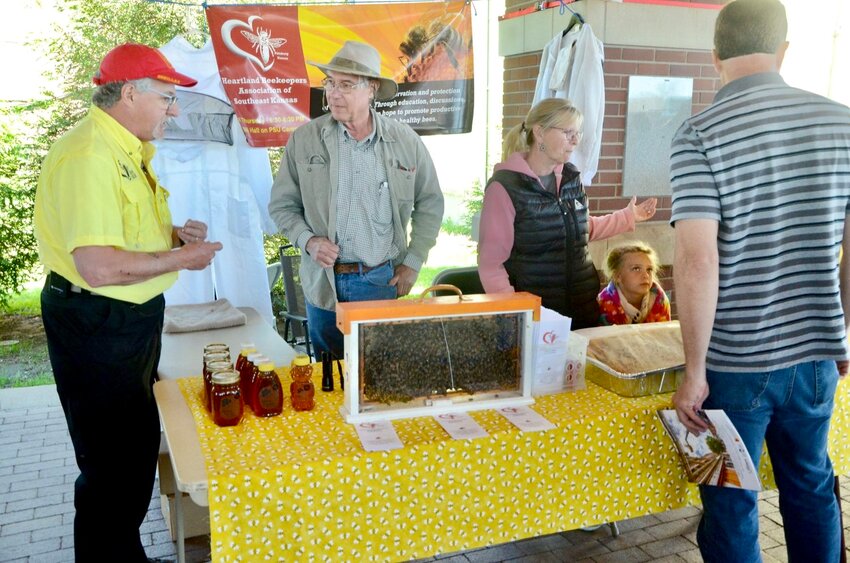 Dan Mosier of the Heartland Beekeepers Association of Southeast Kansas, left, discusses beekeeping with John Hinrichs and other members of the group at its booth at the Pittsburg Earth Day celebration at Pritchett Pavillion in 2019.