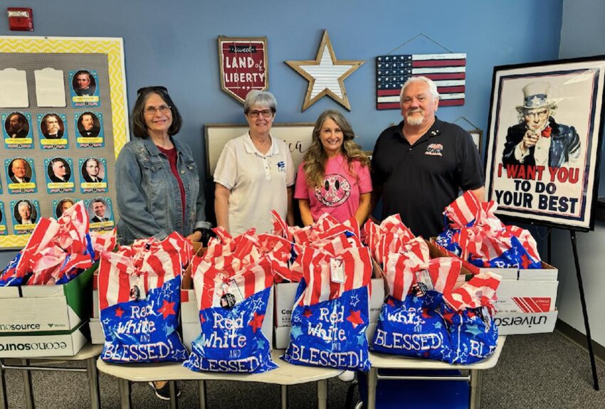 DAR members Janice Brady and Mary Gilpin, left, and SAR member John Gilpin with Parsons Middle School history teacher Debbie Shaffer, and 52 goodie bags to be donated to the Veterans and Guardians of the next Honor Flight to Washington, D.C.
