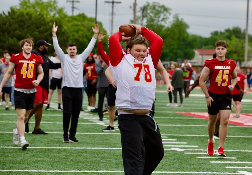 Making his way through the middle of the field, a Special Olympics Kansas athlete spikes the ball as PSU Gorilla football players celebrate during Friday&rsquo;s &ldquo;Victory Day&rdquo; event held at Carnie Smith Stadium.