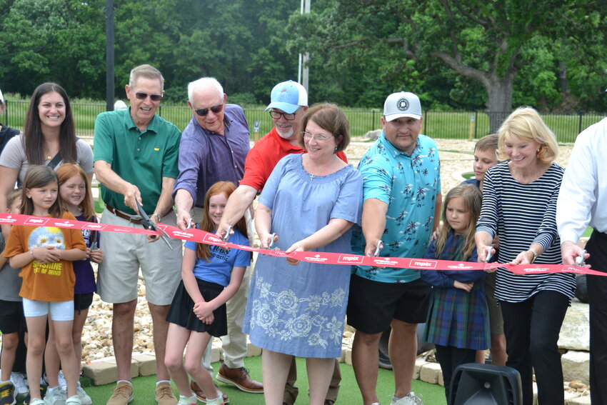 Donors cut the ribbon to officially open the Four Oaks Mini Golf Course on Wednesday. Pittsburg Parks Director Toby Book personally thanked Joe Leek for his efforts as a &ldquo;one-man committee&rdquo; in organizing and raising matching funds to build the course.