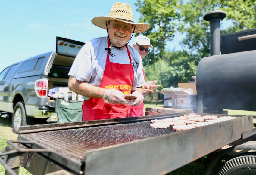 Ken Webb and Douglas Stuckey grill heaping amounts of hamburgers and hotdogs during Friday&rsquo;s summer celebration held on the west lawn of Wesley House. Food was provided courtesy of the Pittsburg Noon Rotary Club and Pittsburg Sunrise Rotary.