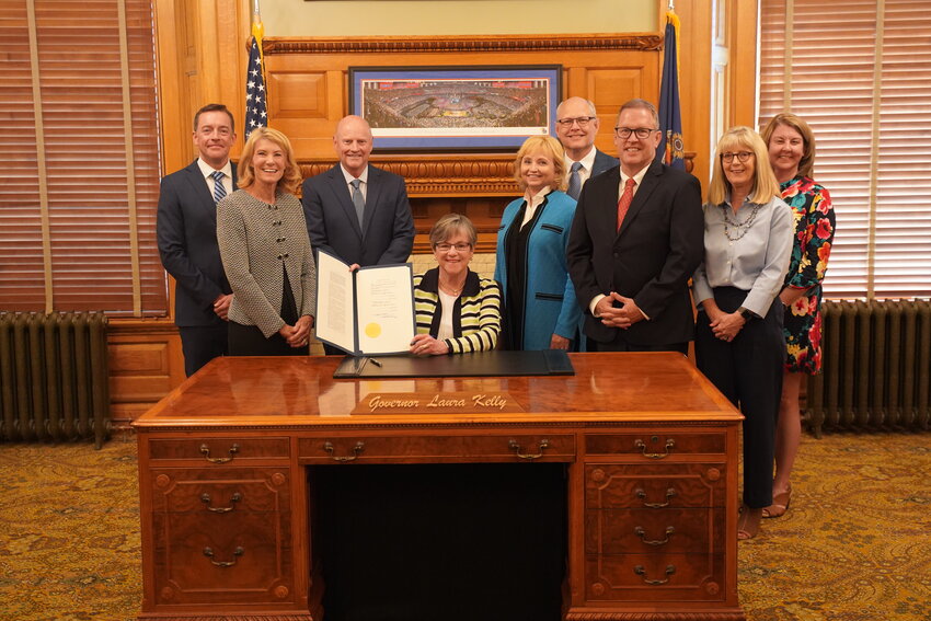 In this official photo from the Office of the Governor, Gov. Laura Kelly shows the legislation she has just signed naming a section of U.S. 69 the Ken W. Brock Memorial Highway. Sharing the occasion, left to right are: Blake Benson, Debbie Brock, Steve Sloan, Sen. Caryn Tyson, Bob Brock, Ron Brock, Cindy Bedene and Pam Henderson.