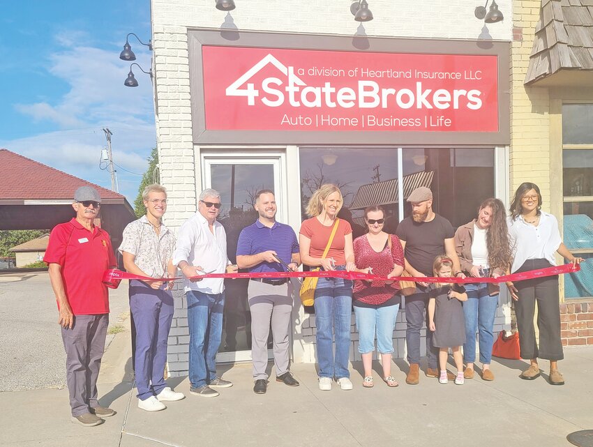 Pittsburg Area Chamber of Commerce members and Dale Clark, center, prepare to cut the ribbon for 4 State Brokers Friday morning.