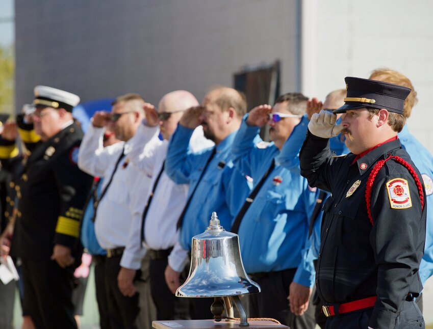 A long line of local fire department members salutes the flag during Sunday&rsquo;s Fallen Firefighter&rsquo;s Memorial Service held at the Girard Fire Department Sunday, marking the 37th year of the service.