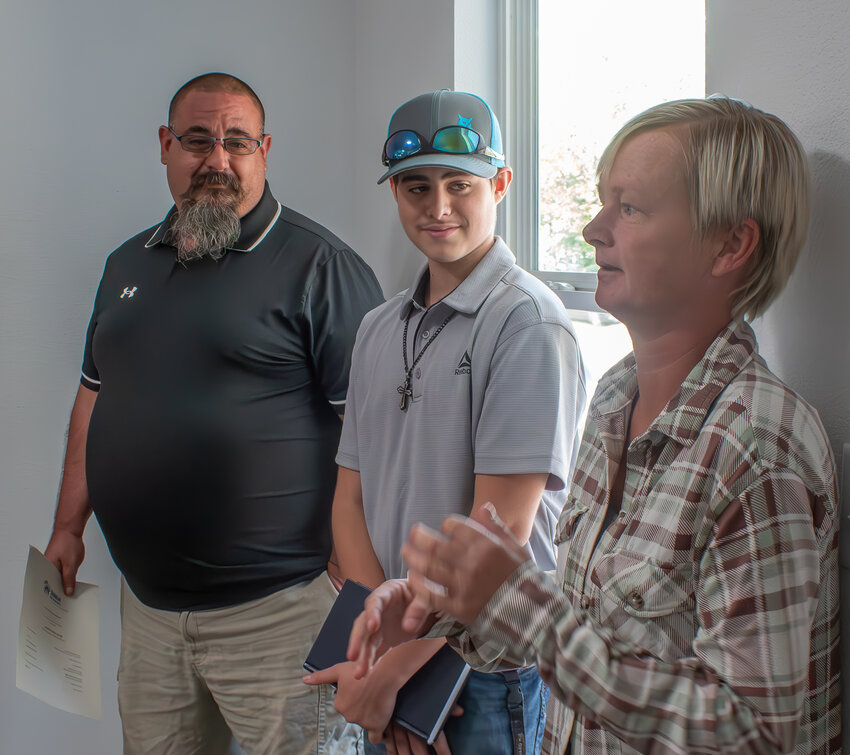 Jessica Fearmonti, right, thanks the Habitat for Humanity of Crawford County for their freshly-built home in Arma as she stands with her son Vincent, middle, and husband James.