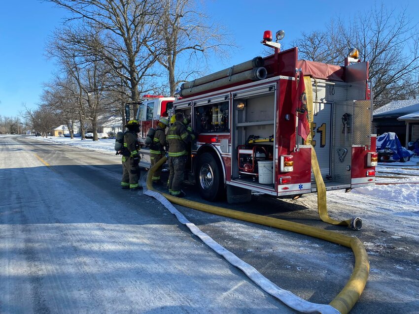 Crew members from the Girard Fire Department work together to fight a structure fire at the 700 block of North Summit St. in Girard Thursday morning.