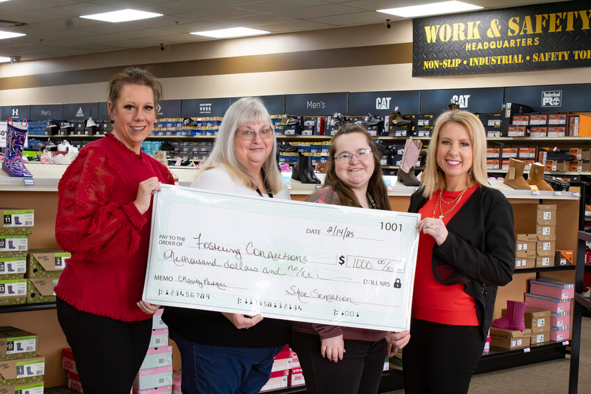 From left, Shoe Sensation Marketing Coordinator Jennifer Pitts, Store Manager Dana Turner, Jaimie Chapman and Fostering Connections Executive Director Lacy Nickelson stand with a check for $1,000 Feb. 14. Shoe Sensation made the donation as part of its customer appreciation event.