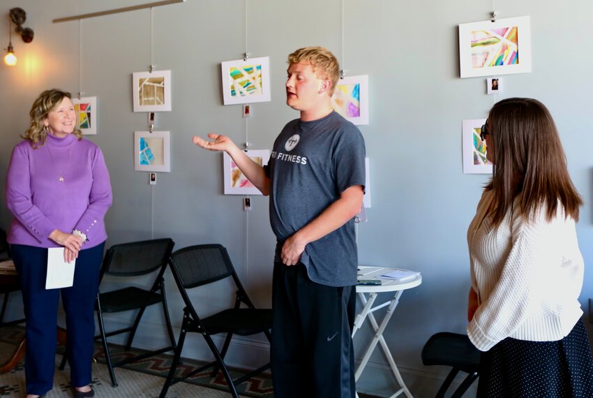 Mosaic member Tyson Wiemers, center, expresses his appreciation alongside Mosaic of Southeast Kansas Executive Director Leslie Lackamp and Mosaic of Southeast Kansas Community Relations Manager Stephanie Potter during Thursday&rsquo;s opening of an art exhibit in Root Coffeehouse in recognition of National Intellectual and Developmental Disabilities Awareness Month.
