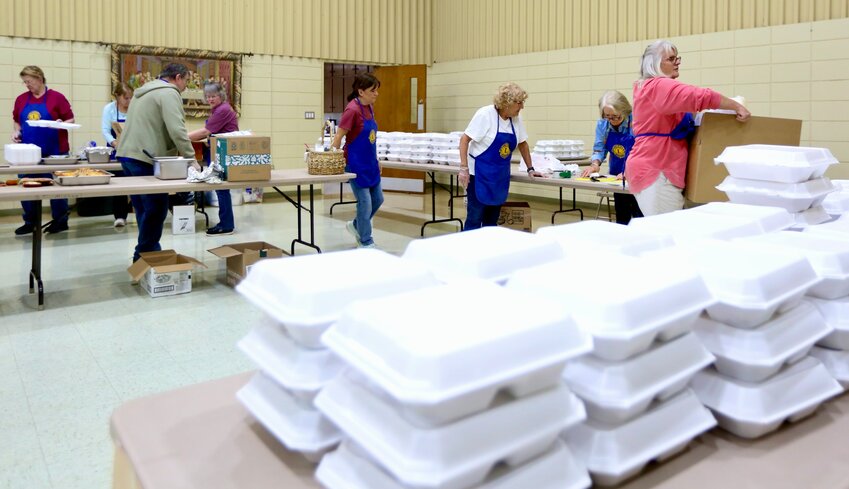 Members of the Girard Lions Club prepare more than 100 containers of lasagna, green beans, salad, bread, and dessert for community members as part of its annual fundraiser held Tuesday at the St. Michael&rsquo;s Catholic Church&rsquo;s Parish Hall in Girard.