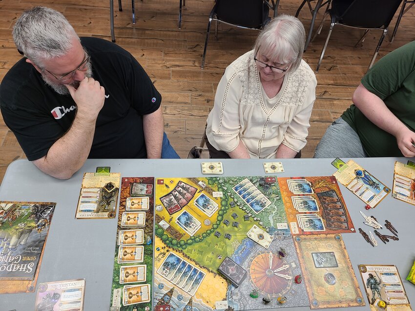 Players contemplate their next moves during Shadows Over Camelot, a semi-cooperative game about King Arthur and the Knights of the Round Table, at the Pittsburg Public Library. The library with the help of SideQuest Games and Hobbies, a group of gaming enthusiasts, hosts monthly game days on Sundays.