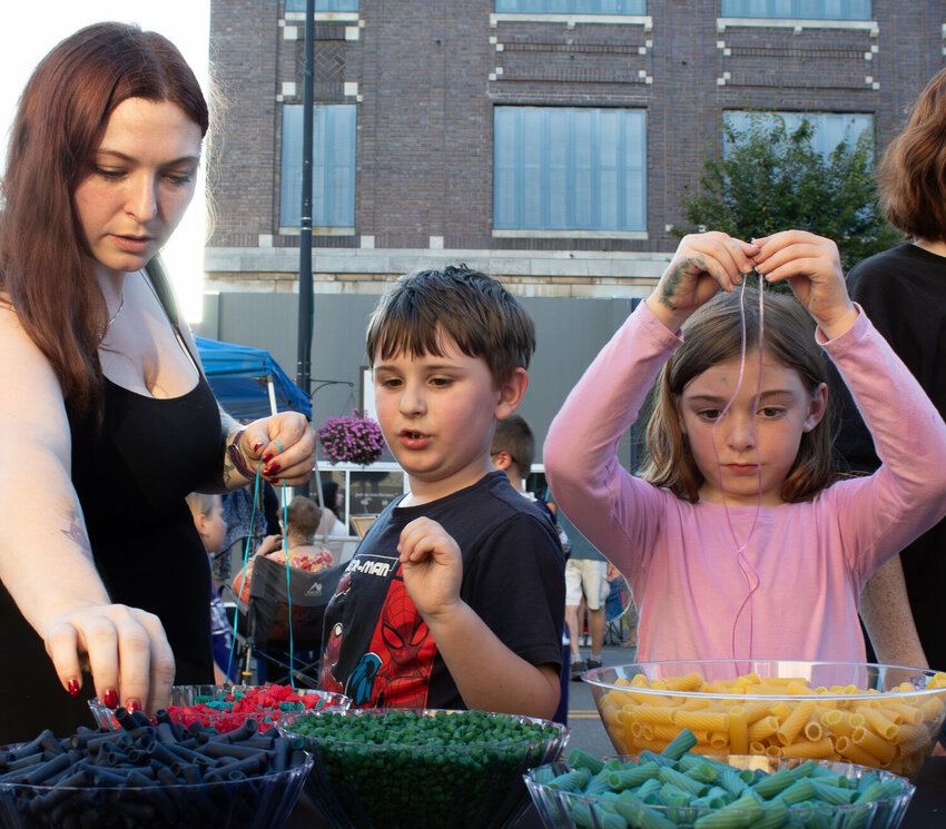Siobhan Masters, left, helps her 6-year-old son Sully Masters pick out pasta beads for his necklace as 7-year-old Melodey Wilson measures her string, right, during the 2024 Fall ArtWalk.