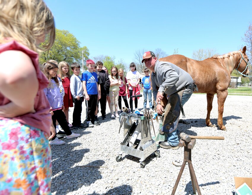 Ryan Hribar, owner and farrier at Arrow H Farrier Service, demonstrates how to apply a horseshoe on a horse during Wednesday&rsquo;s Big Truck Day held at Northeast Elementary.