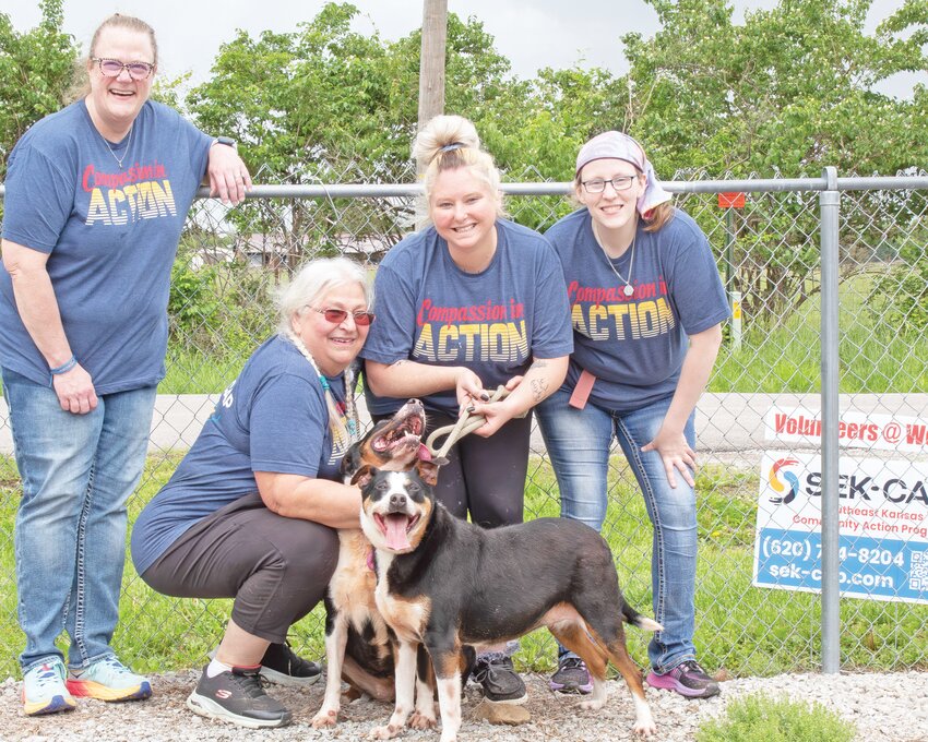From left, Krista Fischer, Vicki Babcock, Karsyn Hensley, and Emilee Turner pose by the fence after walking two dogs at the SEK Humane Society. Volunteers walked dogs, cleaned the facility, socialized animals and much more