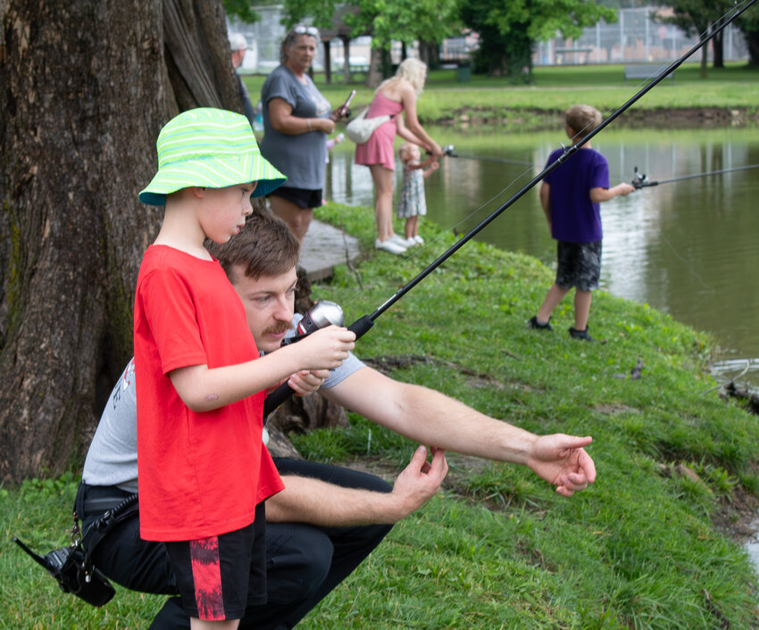 Pittsburg Firefighter Colby Boehm shows 6-year-old Kyren Hamblin to watch his bobber at Lakeside Park for the Hooks and Heroes event. The Kansas Department of Wildlife and Parks provided hooks, poles and bait for community members who wanted to fish.