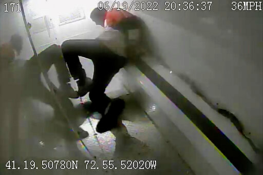 In this photo taken from surveillance video, Richard Cox slides down the back of a police van while being transported after being detained by New Haven Police, June 19, 2022, in New Haven, Conn. Officials in Connecticut said, Wednesday, June 22, 2022, that two New Haven officers have been placed on paid leave and three others were reassigned after Cox was seriously injured in the back of a police van. (New Haven Police via AP)