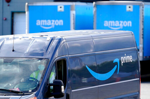 FILE - An Amazon Prime logo appears on the side of a delivery van as it departs an Amazon Warehouse location in Dedham, Mass., Oct. 1, 2020. Amazon has complained to federal regulators that they are hounding company founder Jeff Bezos and senior executives, making “impossible-to-satisfy demands” in their investigation of Amazon Prime. (AP Photo/Steven Senne, File)