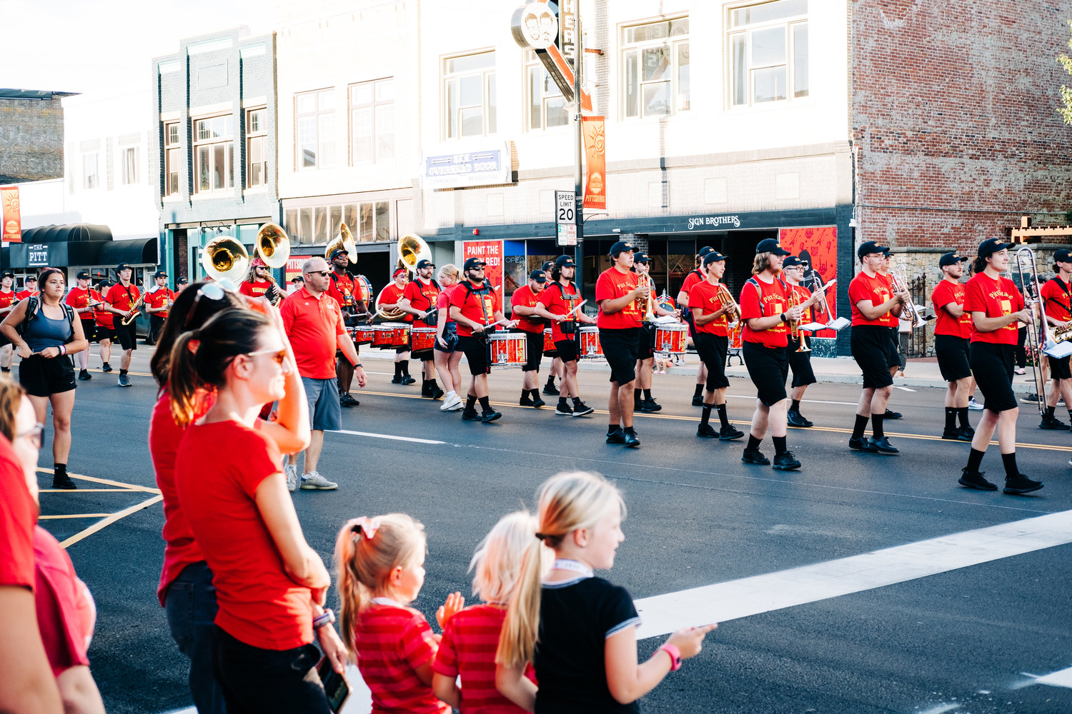 The Pride of the Plains Marching Band marches down Broadway as community members watch during the Paint the Town Red Block Party on Wednesday, Aug. 31.
