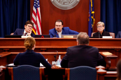 Members of the Michigan Board of State Canvassers, from left, Richard Houskamp, Anthony Daunt and Mary Ellen Gurewitz listen to attorneys Olivia Flower and Steve Liedel during a hearing, Wednesday, Aug. 31, 2022, in Lansing, Mich. The elections board rejected an abortion rights initiative after its two Republican board members voted against putting the proposed constitutional amendment on the November ballot. The two Democrats voted in favor, but getting the measure on the ballot required at least three votes of the four-member board. (AP Photo/Carlos Osorio)