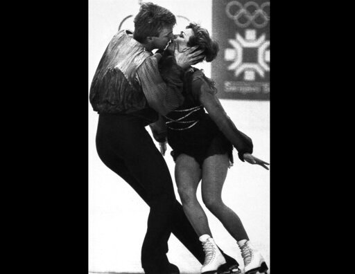 FILE - Britain's Jayne Torvill and Christopher Dean kiss during their performance in the Olympic ice dancing at the Winter Olympics in Sarajevo, Bosnia on Feb. 14, 1984. Caulkin, a retired Associated Press photographer who captured the iconic moment when ice dancers Jayne Torvill and Christopher Dean won the 1984 Olympic gold medal, has died. He was 77 and suffered from cancer. (AP Photo/Dave Caulkin, File)