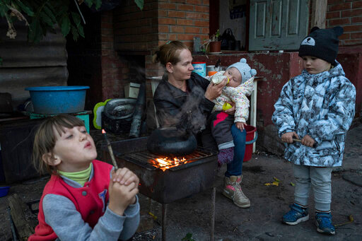 Margaryta Tkachenko, 29 years old, feeds her 9-month-old daughter Sophia in the recently retaken town of Izium, Ukraine, Sunday, Sept. 25, 2022. (AP Photo/Evgeniy Maloletka)