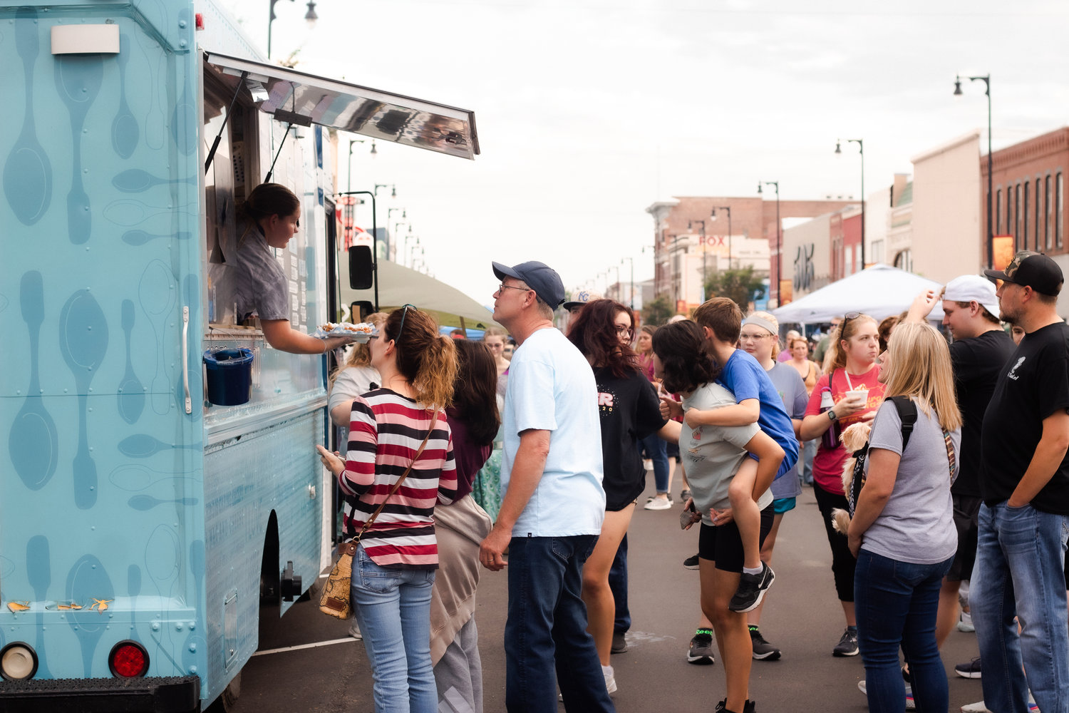 ArtWalk attendees wait in line at the Blue Spoon, one of the many food trucks at the Pittsburg ArtWalk on Friday. This season’s Artwalk featured over 20 vendors and organizations, and more than 50 artists.