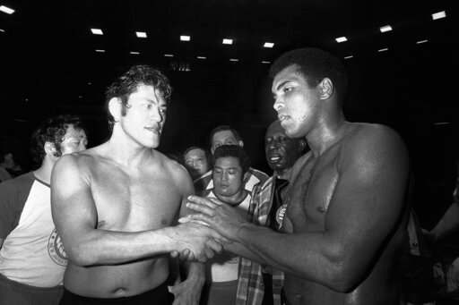 CORRECTS TO 1976, NOT 1979 - FILE - Wrestler Antonio Inoki, left, and world heavyweight boxing champion Muhammad Ali shake hands after a 15-round boxing- wrestling fight on June 26, 1976, at Tokyo's Budokan hall. A popular Japanese professional wrestler and lawmaker Antonio Inoki, who faced a world boxing champion Muhammad Ali in a mixed martial arts match in 1976, has died at 79. The New Japan Pro-Wrestling Co. says Inoki, who was battling an illness, died earlier Saturday, Oct. 1, 2022. (AP Photo, File)