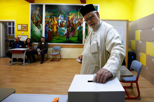 A priest casts his vote at the opening of the polling stations in Sofia, Sunday, Oct. 2, 2022. Bulgarians on Sunday cast their ballots in a general election – the fourth in 18 months - marked by a raging war nearby, by political instability, and economic hardships in the European Union poorest member. (AP Photo/Valentina Petrova)