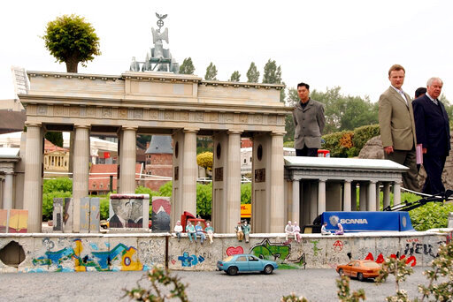 FILE - Visitors walk by a replica of the Brandenberg Gate and the Berlin wall at Mini-Europe in Brussels, Tuesday May 11, 2004. With the entrance of ten new members to the EU on May 1, 2004, Mini-Europe faced having to expand as well. Leaders from more than 40 countries will gather Thursday, Oct. 6, 2022, in Prague, to launch a "European Political Community" aimed at boosting security and economic prosperity across the continent, but critics claim the new forum is an attempt to put the brakes on European Union enlargement. (AP Photo/Virginia Mayo, File)