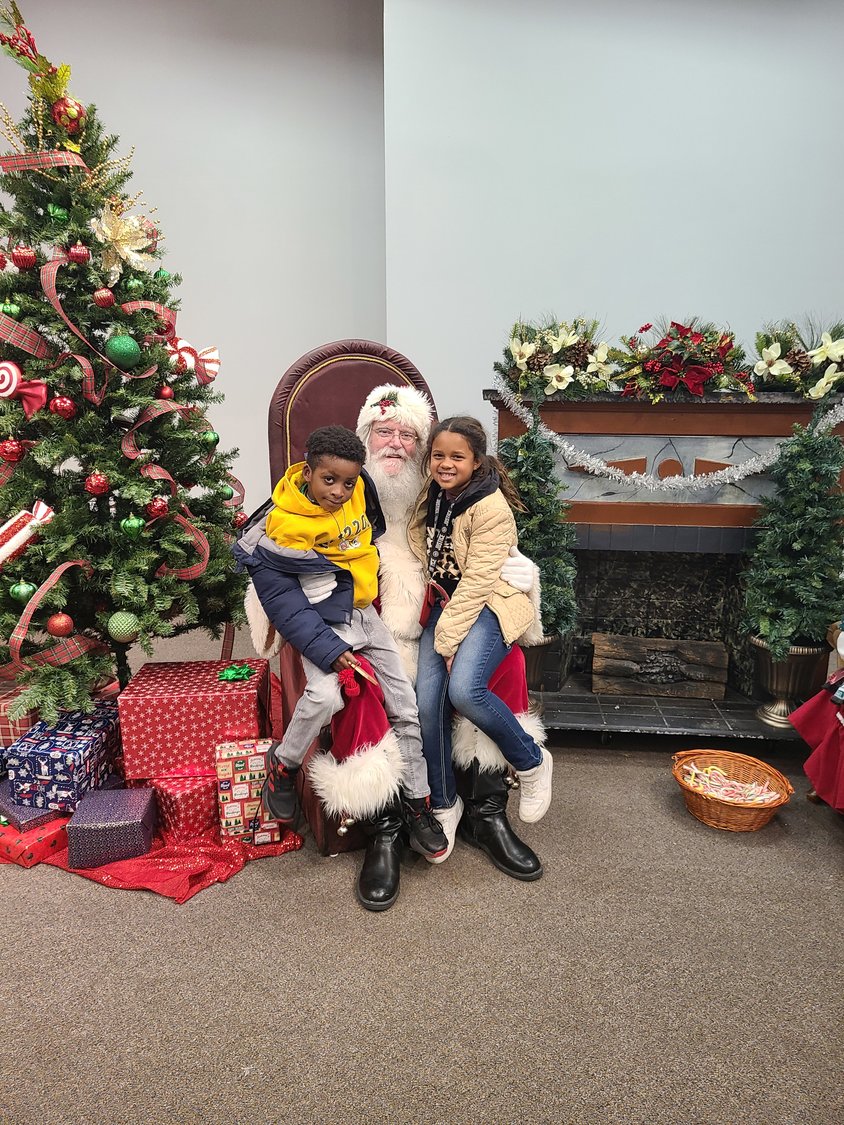 Kyliea Stuart and Steven Taylor sit on Santa’s lap at Santa’s Workshop during the Holiday Craft Fair at Memorial Auditorium on Saturday. Santa’s Workshop not only had Santa and Mrs. Claus on hand for photo opportunities, it also featured coloring pages available for the kids to color.
