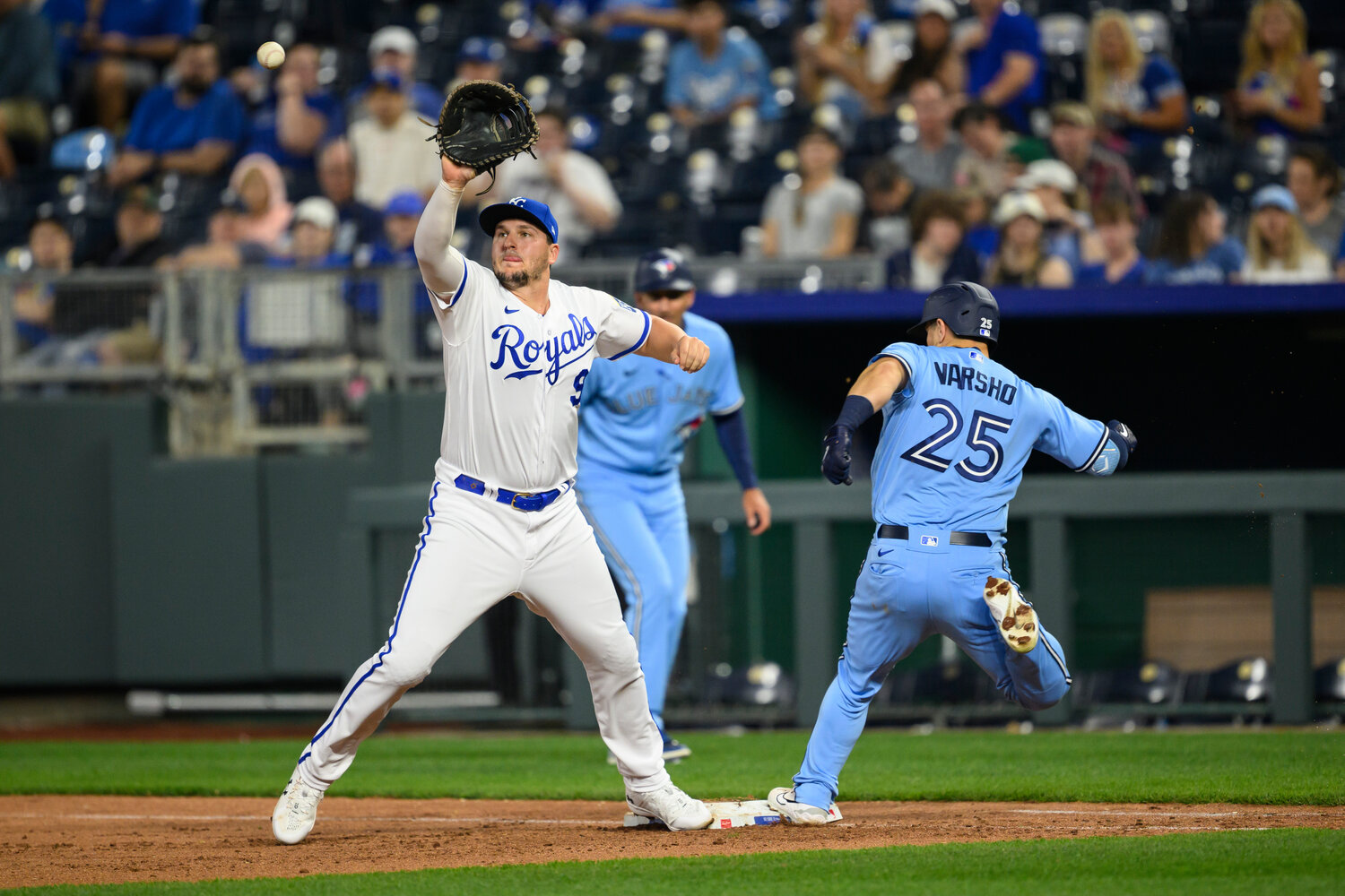 Toronto Blue Jay's Daulton Varsho (25) is safe at first on a late throw to Kansas City Royals first baseman Vinnie Pasquantino (9) during the eighth inning of their game on Tuesday in Kansas City, Mo. (AP Photo/Reed Hoffmann)