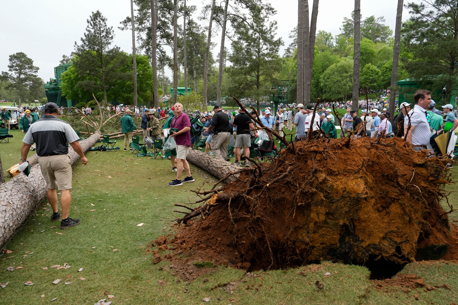 Patrons move away from two trees that blew over on the 17th hole during the second round of the Masters on Friday at Augusta National Golf Club in Augusta, Ga. (AP Photo/Mark Baker)