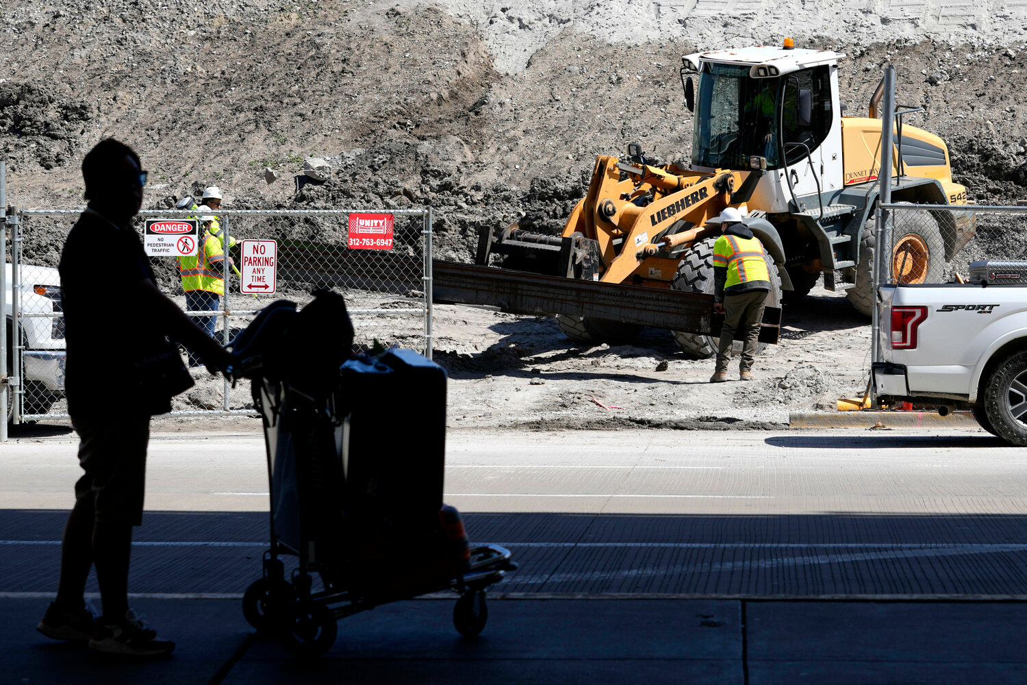 Construction workers work at O'Hare International Airport terminal 5 parking lot, Tuesday, April 18, 2023, in Chicago. (AP Photo/Nam Y. Huh)
