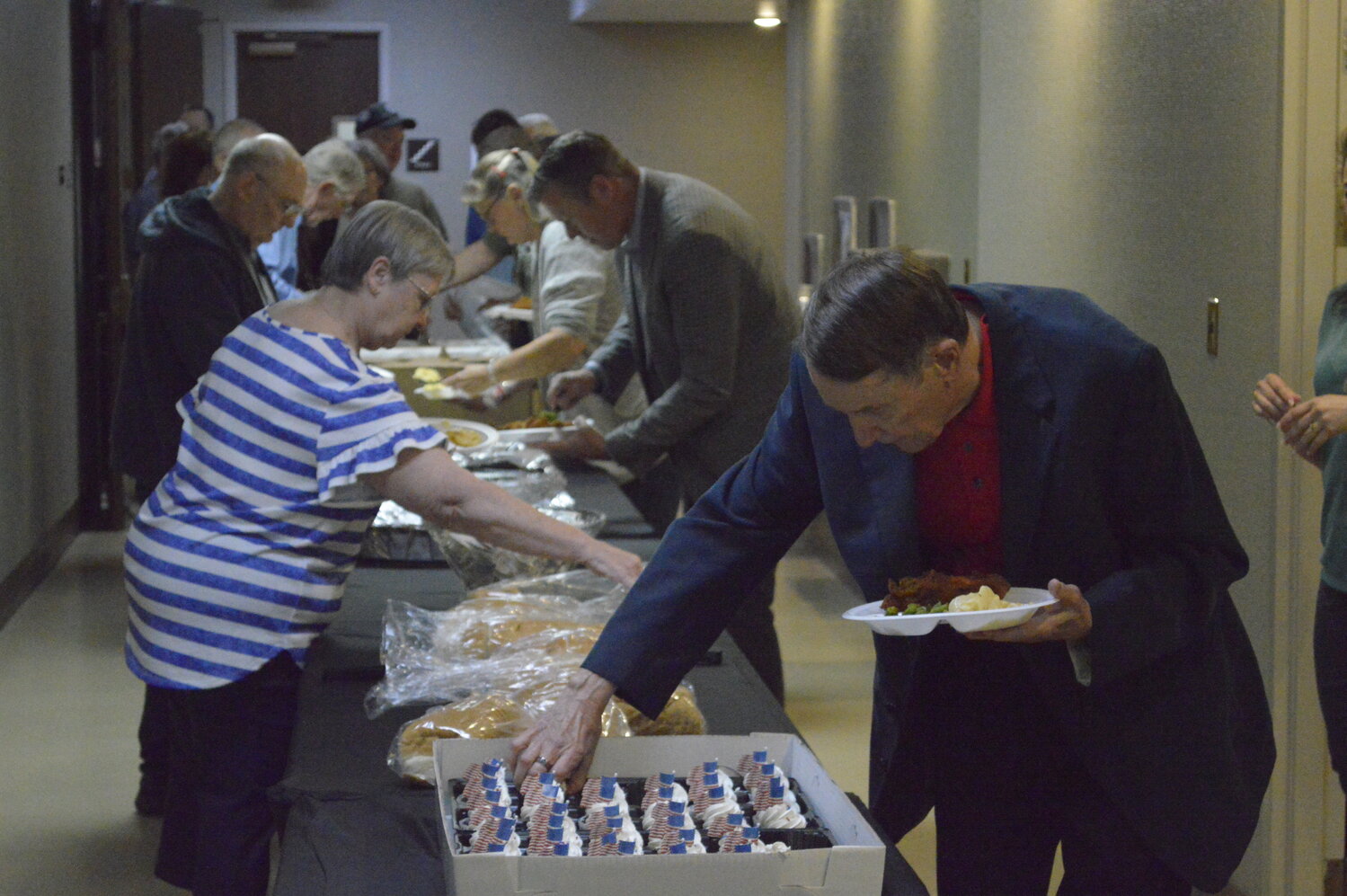 Bert Patrick (right) reaches for a cupcake during the Crawford County Republican Party’s Dinner and Discussion event Saturday, May 20 at Pittsburg’s Memorial Auditorium.