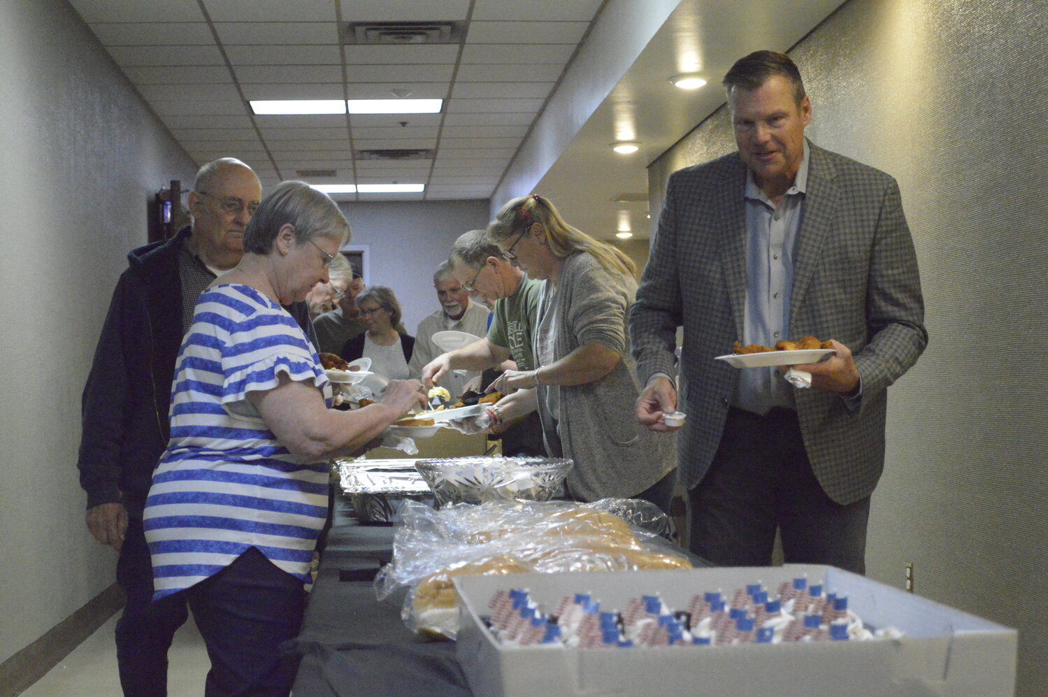 Kansas Attorney General Kris Kobach (right) grabs himself a plate of fried chicken Saturday night during the Crawford County Republican Party’s Dinner and Discussion event.