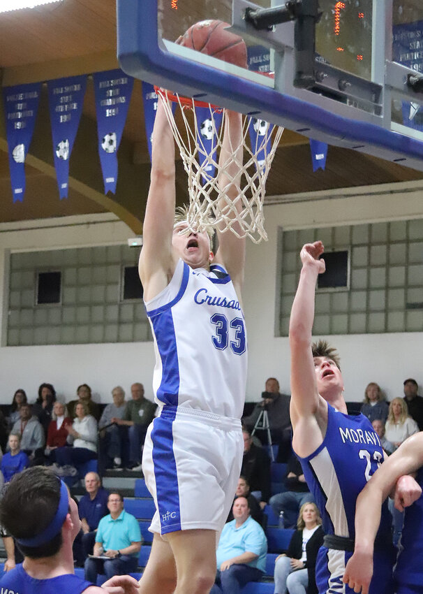 Holy Trinity senior Conner Gehling (33) slams a ball home in the third quarter of the Crusaders' 55-29 win over Moravia in Class 1A District 10 semifinal action Thursday in Fort Madison.
