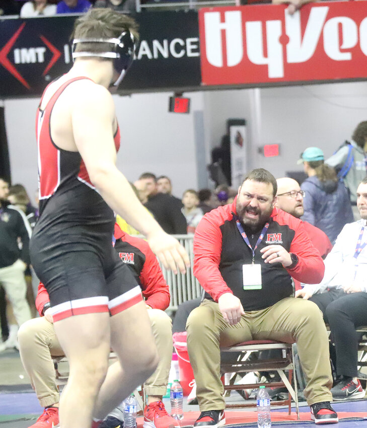 Fort Madison Head Coach Ryan Smith shouts some instructions to Ike Thacher during his final match Saturday morning at Wells-Fargo Arena in Des Moines at the IHSAA boys State Wrestling Tournament.