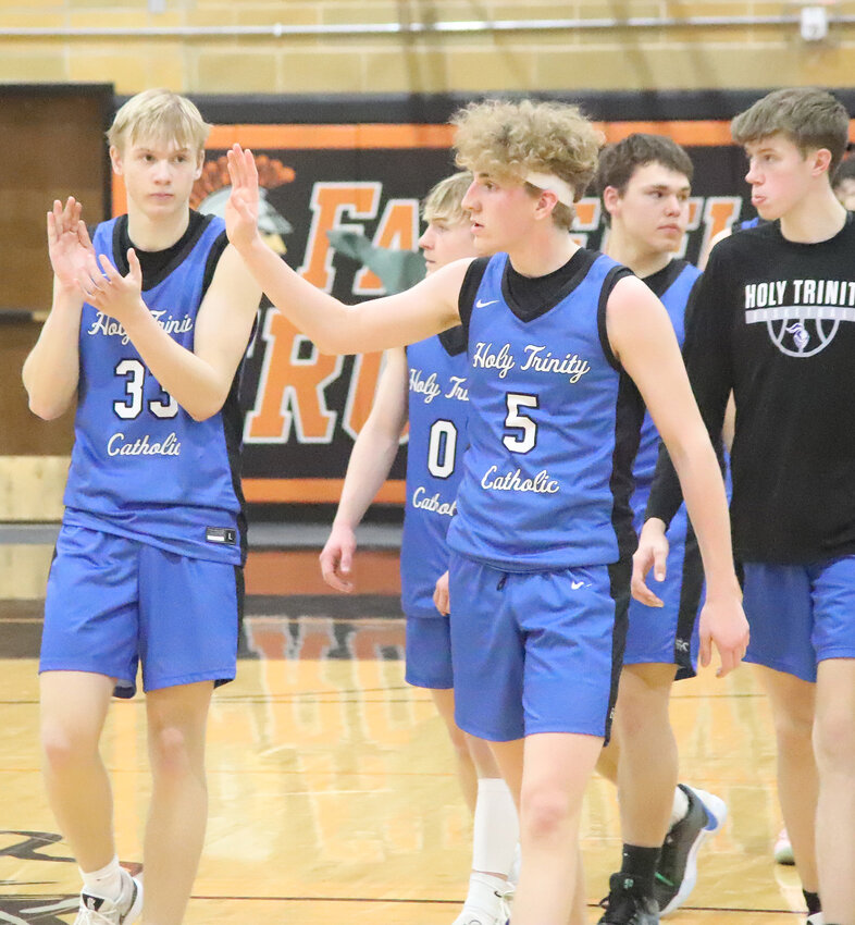 Seniors Conner Gehling, left, and Maddox Rung, right wave to the Holy Trinity fans after the Crusaders fell to Winfield-Mt.Union 46-41 in Saturday's Class 1A substate final in Fairfield.