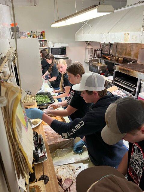 Alexys Hartman , Adelyn Lampe, Finley Johnson , Kenzie Johnson , Hadley Johnson, Ben Blanchard, and Jake Ahlers help prepare a meal at Saturday's FFA event in Fort Madison