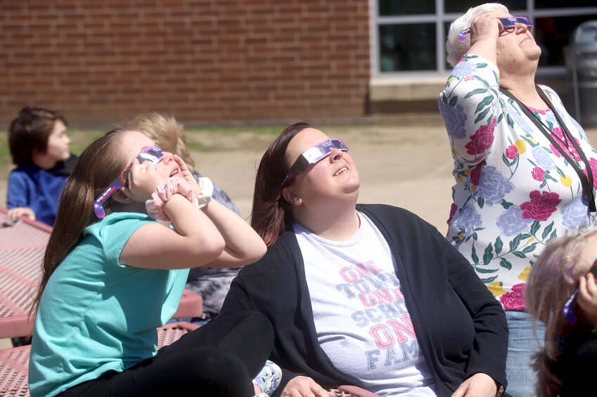 Students and associates at Fort Madison Middle School look up in the south sky at Monday's solar eclipse through special viewing glasses provided by the school.