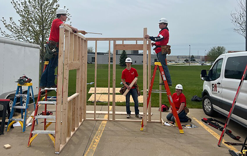 Hadley Johnson, Ames Schinstock, Taylor Huffman, and Ben Blanchard work on a framed-up two-wall project at the state Skill USA competition Thursday at DMACC in Des Moines.
