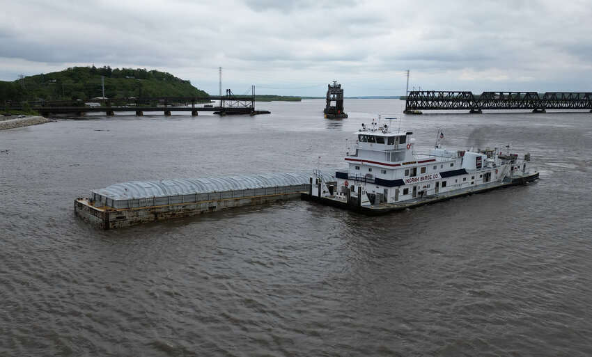 A towboat tries to push a section of barge to shallower waters as crews try to rein in several sections that got loose after striking the BNSF Railbridge in Fort Madison Thursday at about 1:15 p.m.