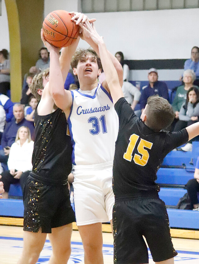 HTC's Luke Hellige (31) puts up a shot earlier this season between two defenders. He scored 43 Monday night to help HTC get to round 2 of substate district action.