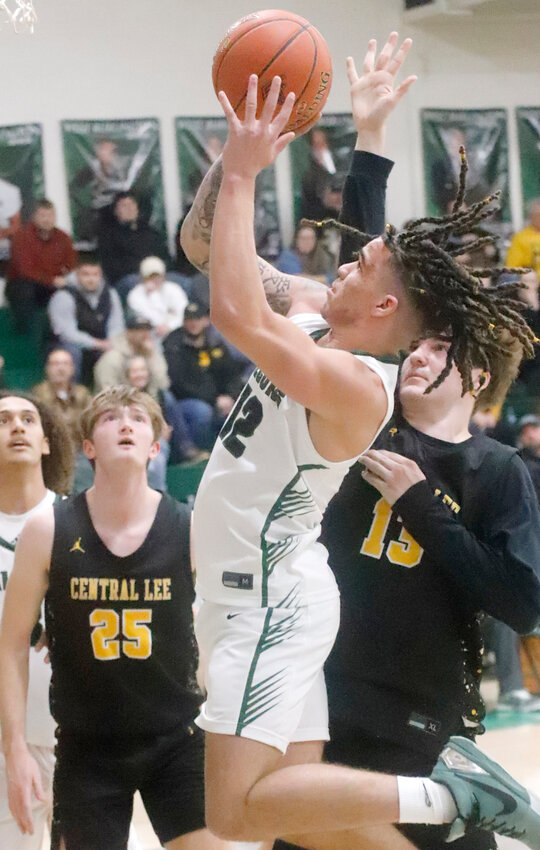 West Burlington's Quincy Collins goes up for a shot between Central Lee's Will Hayes (13) and Brayden Wyrick (25) in Thursday night in West Burlington.  The Hawks' season ended with a 75-57 loss in the regional quarterfinals.