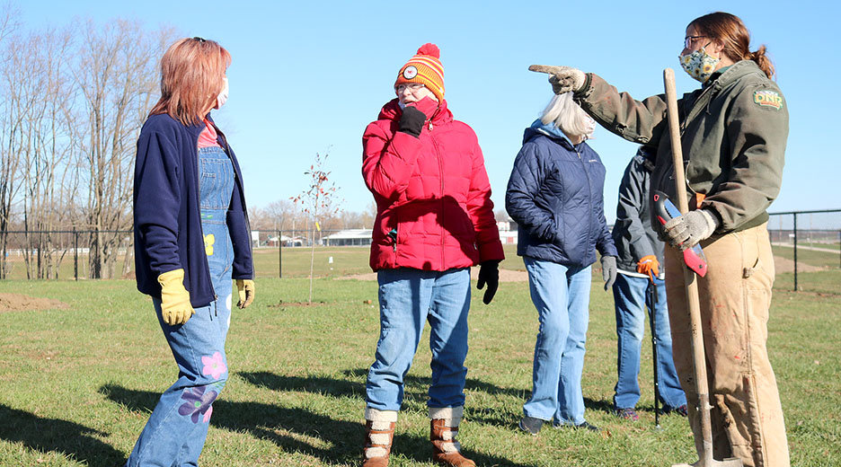 Donna Amandus, left, and Sharman Steeples, talk with a DNR officer during a tree planting in November at the Canine Corral in Fort Madison. A matching $5,000 anonymous donation is now in play to help pay for cement paths at the park. PCC File photo