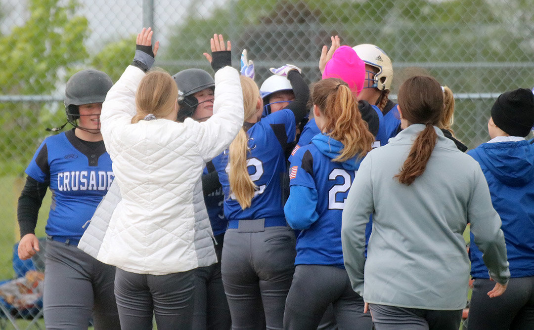 Holy Trinity sophomore Kayla Box gets high fives from teammates after a 3-run homer in the bottom of the first inning of the Crusaders 9-8 win over Danville Friday at South Park. Photo by Chuck Vandenberg/PCC
