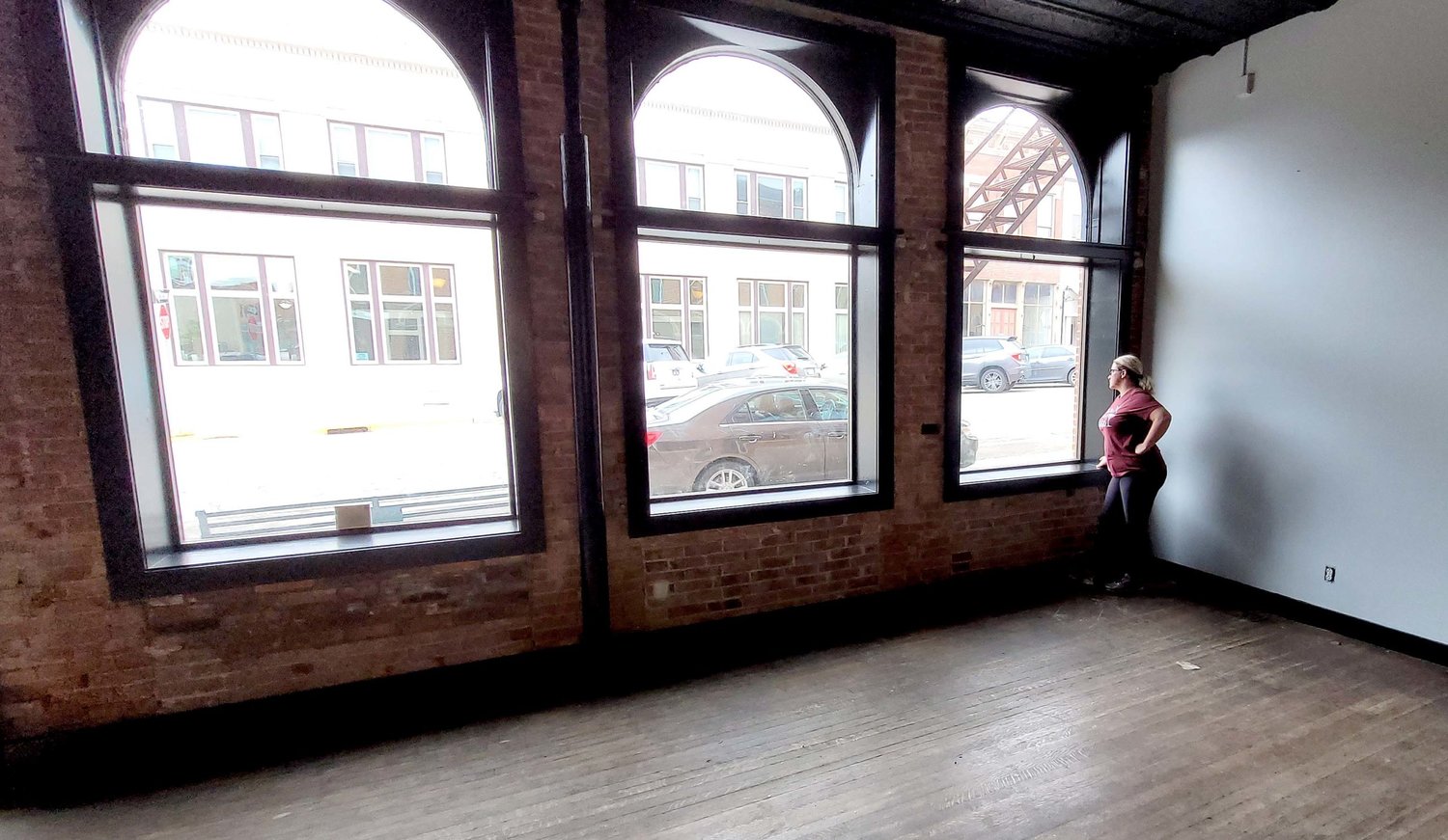 Angela Hedges looks out the windows at her new location in the Hesse Building at 7th and Avenue G in Fort Madison. Hedges is planning to open Corks and Barrels in July downtown. Photo by Chuck Vandenberg/PCC
