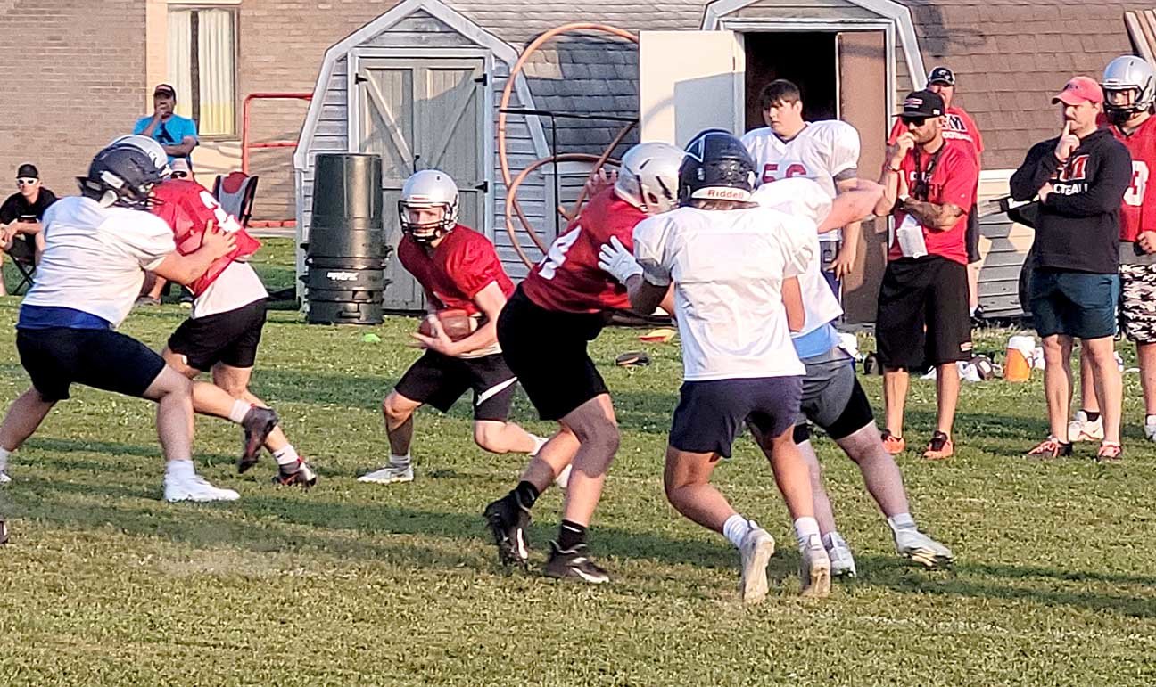 FM quarterback Landes Williams breaks through the line in a drill earlier this month in Fort Madison. The Hounds open the season Friday with a 7:30 p.m. game for the county seat against Keokuk. Photo by Chuck Vandenberg/PCC
