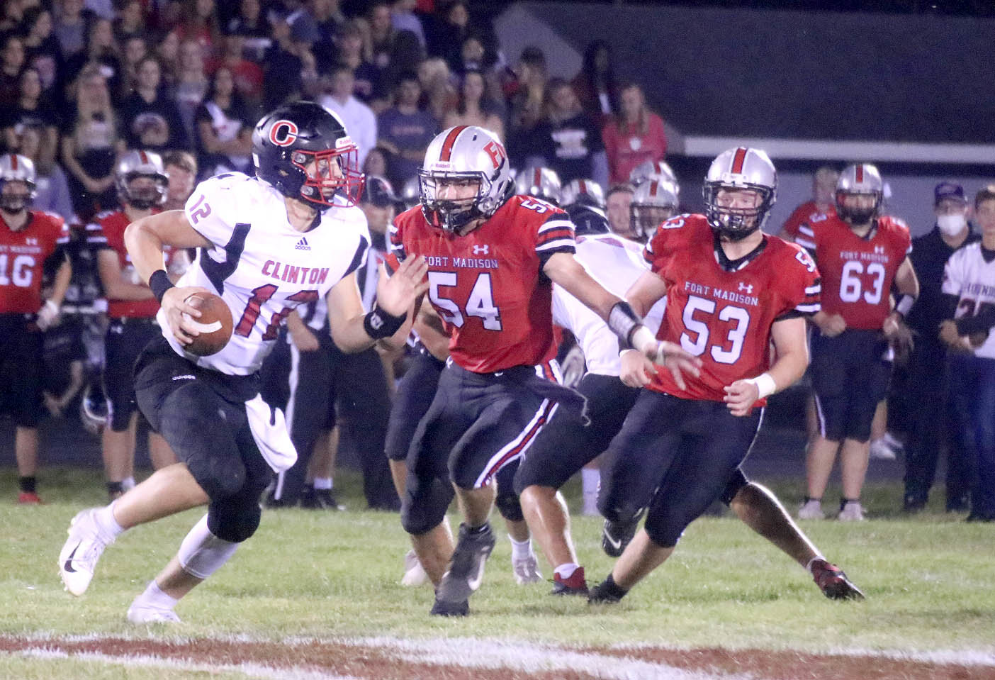 Fort Madison's Austin Ensminger (54) and Daniel Sokolik (53) chase down Clinton QB Jai Jensen in the first quarter of Friday's 58-14 win over Clinton. Photo by Chuck Vandenberg/PCC