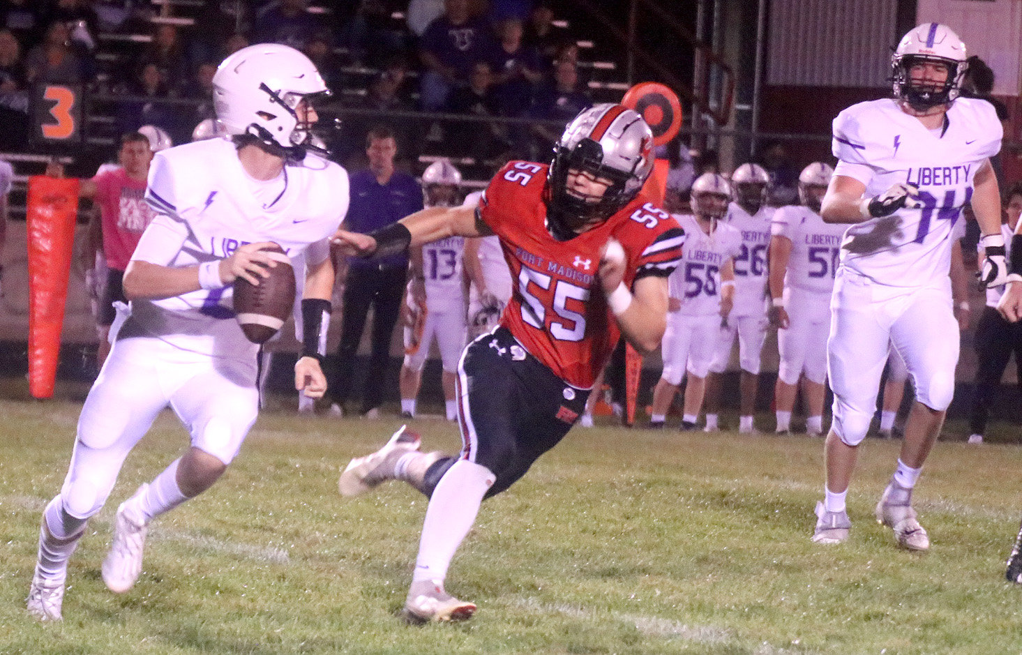 Fort Madison's Tanner Settles (55) chases down Iowa City Liberty quarterback Tye Hughes in the first period. The Bloodhounds suffered their first loss of the year 24-16 to move to 6-1. Photo by Chuck Vandenberg/PCC