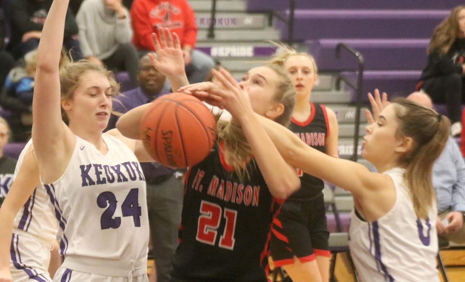 Fort Madison's Camille Kruse gets mugged trying to score in the lane in the first quarter Friday night in Keokuk. The Hounds fell 50-46. Photo by Chuck Vandenberg/PCC